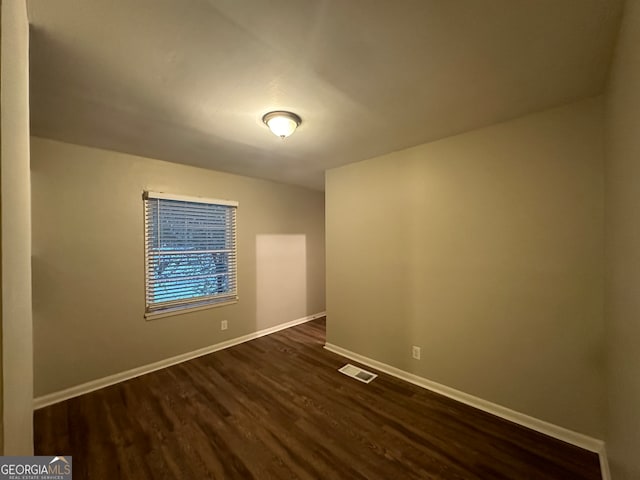 spare room with dark hardwood / wood-style floors