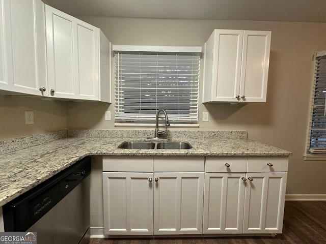 kitchen with white cabinets, dark hardwood / wood-style flooring, light stone countertops, stainless steel dishwasher, and sink