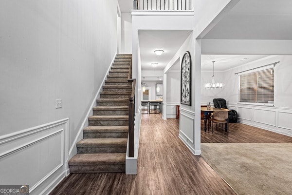 staircase featuring a notable chandelier and carpet floors