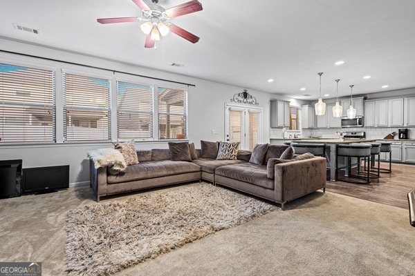 living room featuring ceiling fan and light hardwood / wood-style flooring