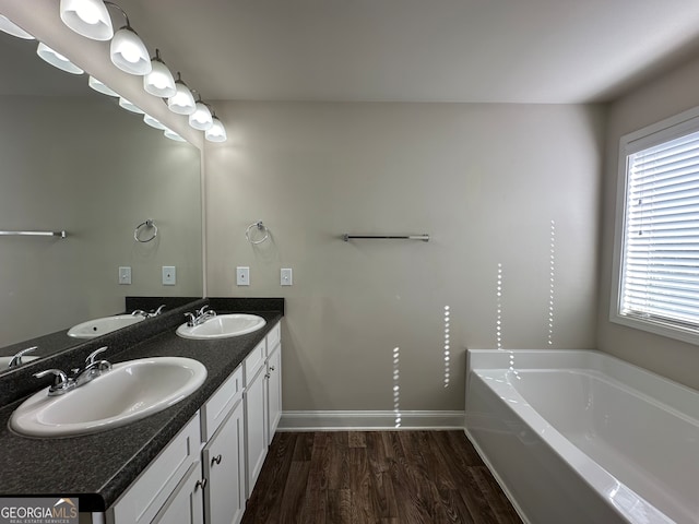 bathroom featuring vanity, a tub, and hardwood / wood-style floors