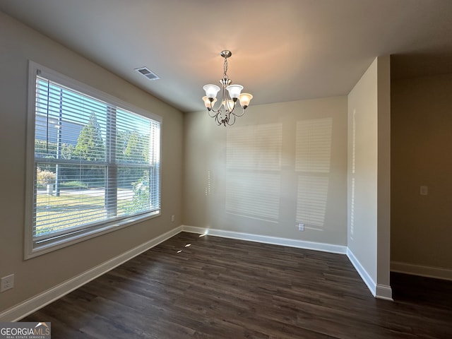 unfurnished dining area featuring a notable chandelier and dark hardwood / wood-style floors