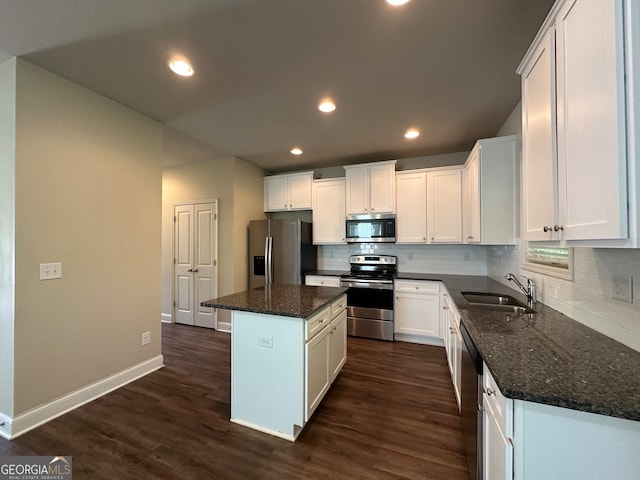 kitchen with a kitchen island, dark wood-type flooring, stainless steel appliances, sink, and white cabinets