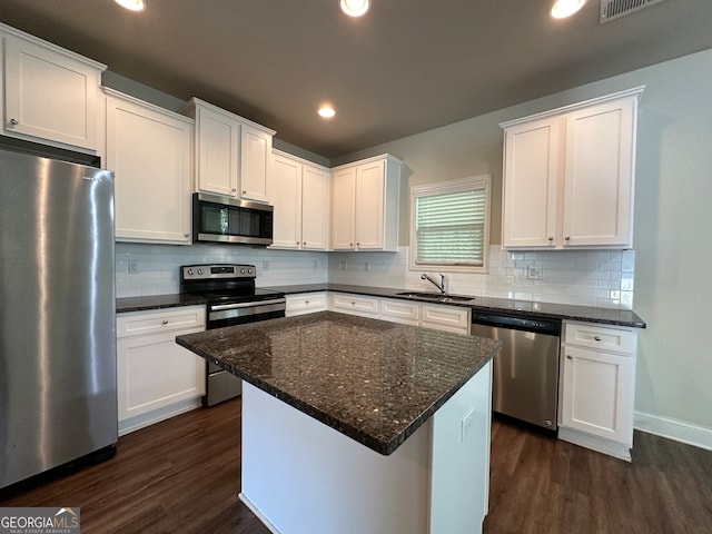 kitchen featuring dark hardwood / wood-style floors, sink, a center island, white cabinets, and appliances with stainless steel finishes