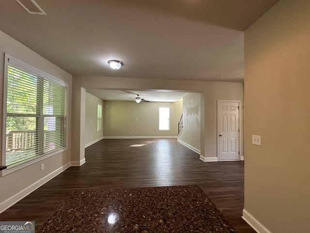 empty room with ceiling fan and dark hardwood / wood-style flooring