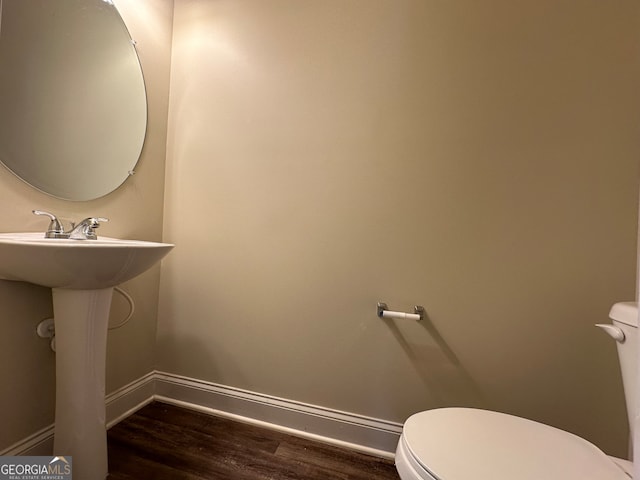 bathroom featuring hardwood / wood-style flooring and toilet