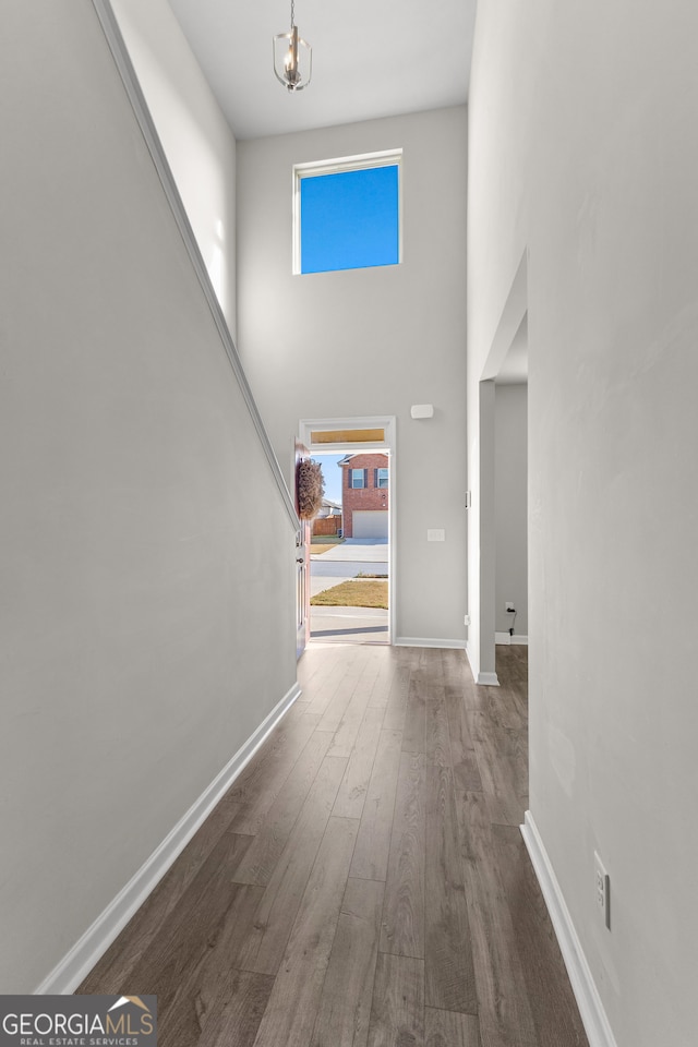 hallway featuring dark hardwood / wood-style floors and a towering ceiling