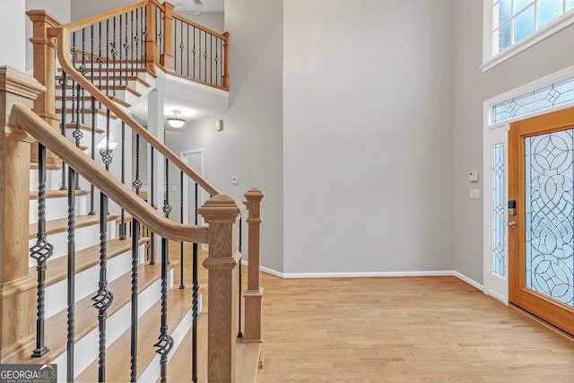 entrance foyer with a high ceiling and light hardwood / wood-style floors