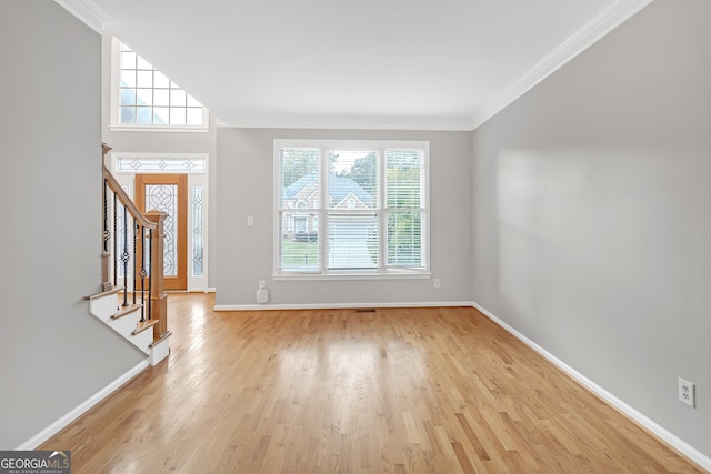 entryway featuring crown molding, light hardwood / wood-style flooring, and a healthy amount of sunlight