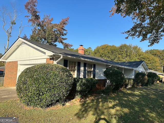 view of property exterior featuring a garage and a lawn