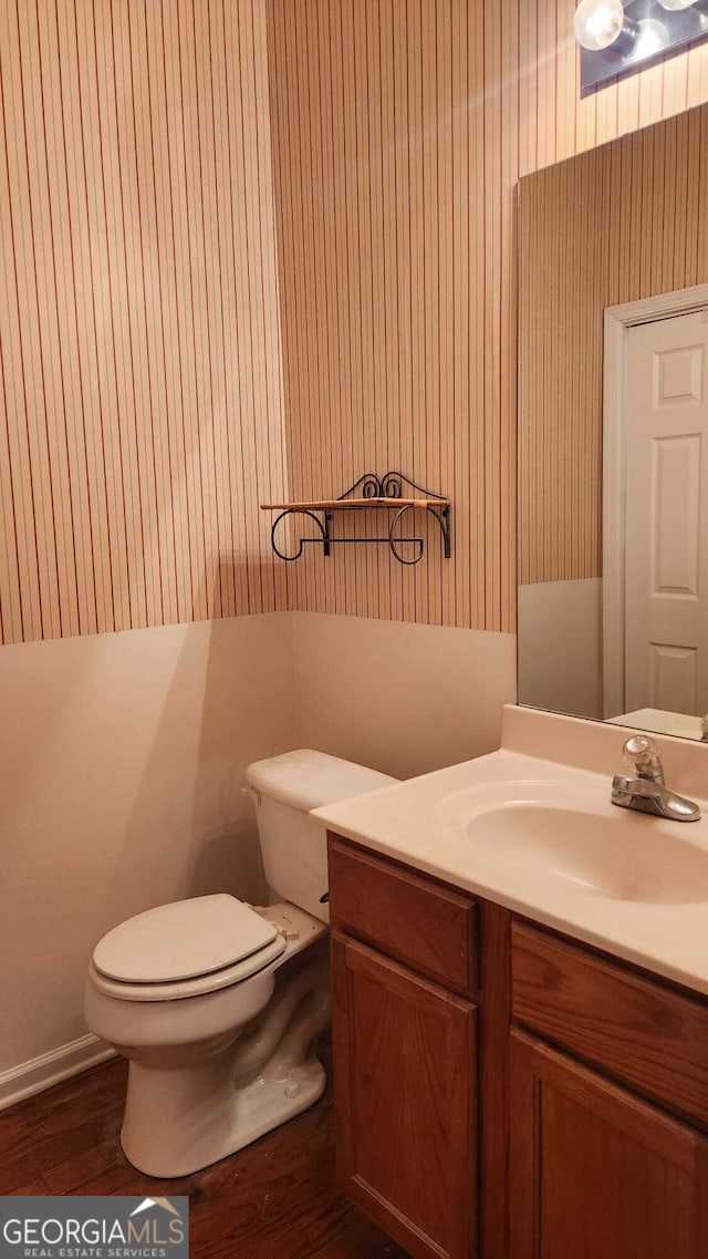 bathroom featuring vanity, toilet, and hardwood / wood-style floors