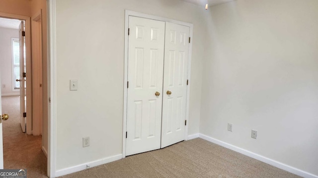 unfurnished bedroom featuring a closet and carpet flooring