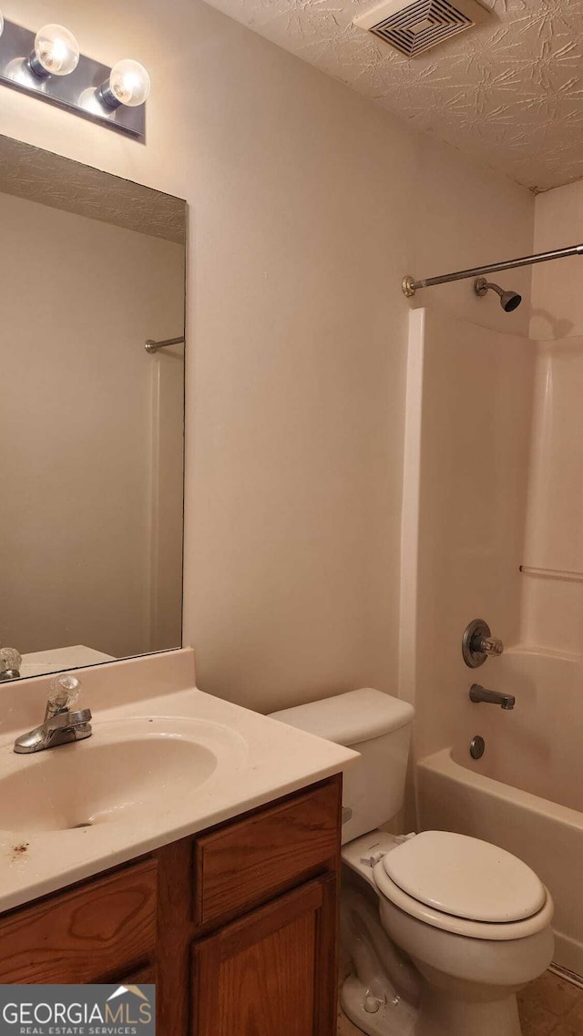 full bathroom with toilet, a textured ceiling, vanity, and  shower combination