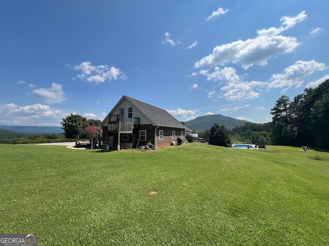 back of house with a mountain view and a yard