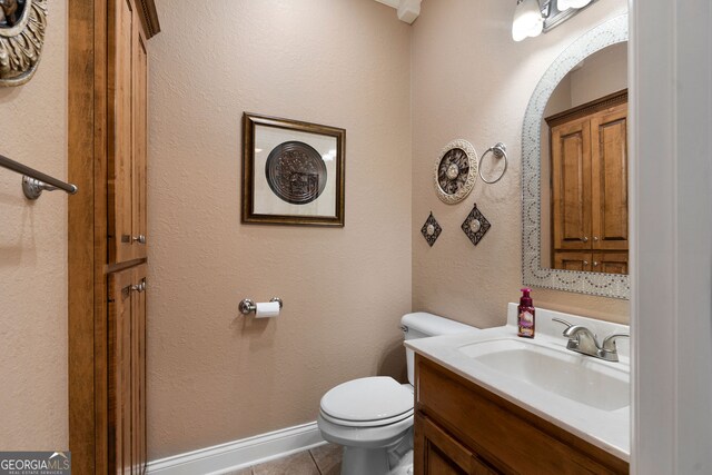 bathroom featuring toilet, vanity, and tile patterned floors