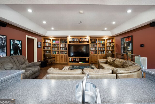 living room featuring built in features and a tray ceiling