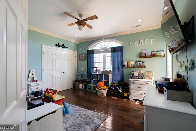 game room with ceiling fan, crown molding, a textured ceiling, and dark hardwood / wood-style floors