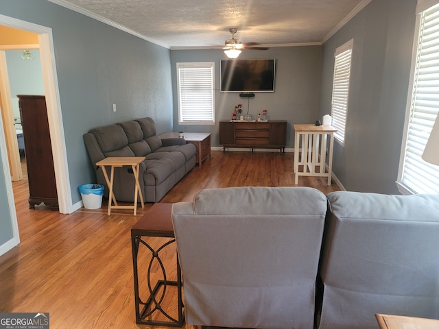 living room featuring crown molding, a healthy amount of sunlight, hardwood / wood-style flooring, and ceiling fan