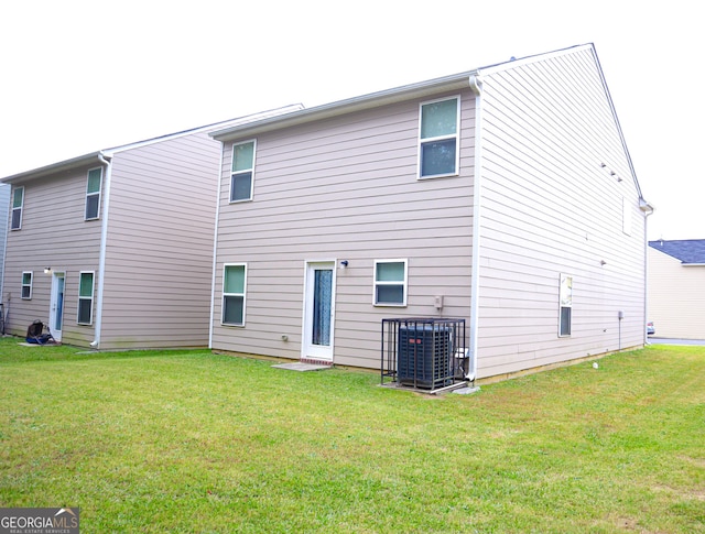 rear view of house with a yard and central air condition unit