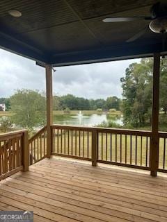 wooden terrace featuring a ceiling fan and a water view