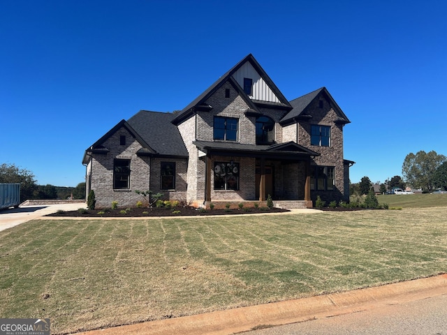 view of front of home with a front lawn, board and batten siding, and brick siding