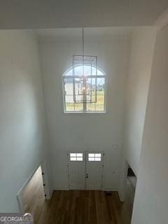 foyer entrance featuring dark wood-type flooring and a notable chandelier