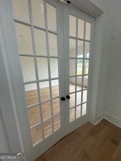 doorway with baseboards, wood finished floors, and french doors