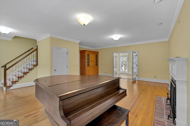 interior space featuring ornamental molding, light wood-type flooring, and a fireplace