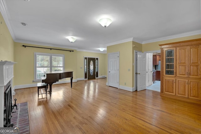 miscellaneous room featuring ornamental molding, a fireplace, and light hardwood / wood-style floors