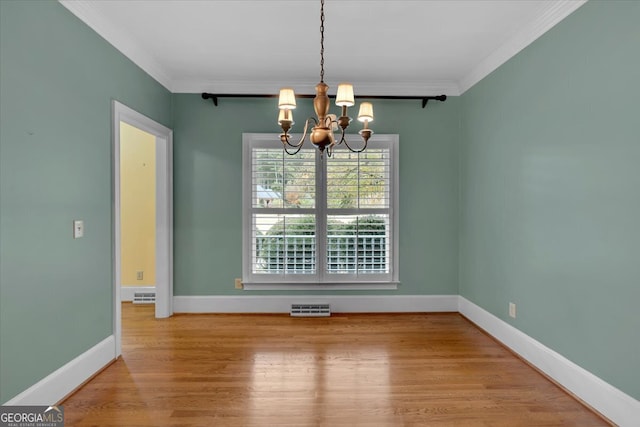 unfurnished dining area featuring crown molding, a chandelier, and wood-type flooring