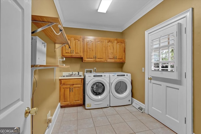 washroom with cabinets, ornamental molding, light tile patterned flooring, and washer and clothes dryer