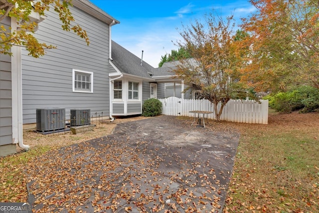 rear view of house with central air condition unit and a patio