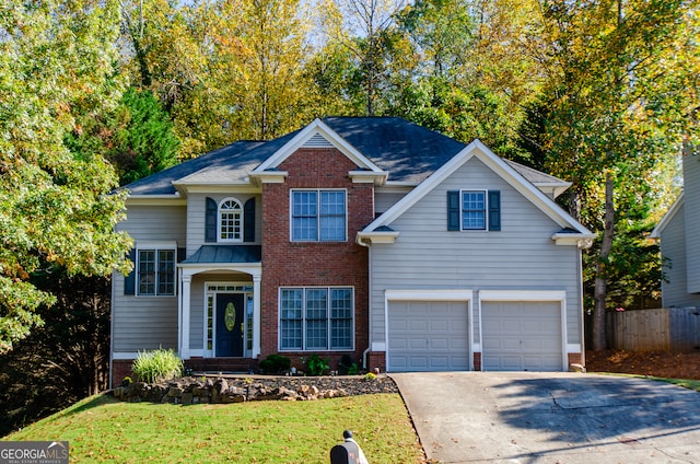 view of property featuring a garage and a front lawn