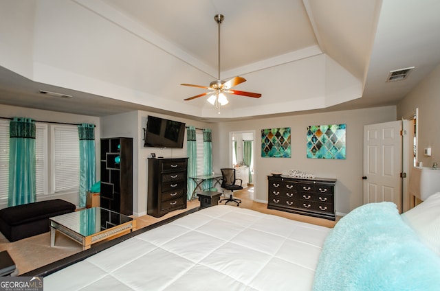 bedroom featuring a raised ceiling, hardwood / wood-style flooring, and ceiling fan