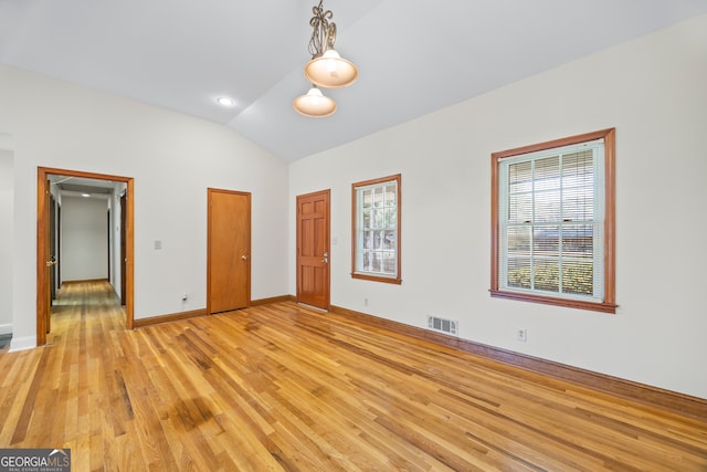 unfurnished bedroom featuring lofted ceiling, light hardwood / wood-style flooring, and multiple windows