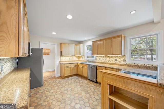 kitchen featuring appliances with stainless steel finishes, a wealth of natural light, and decorative backsplash