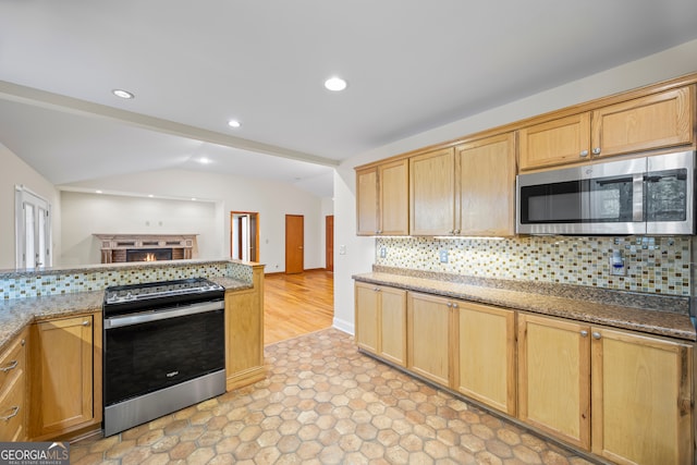 kitchen with stone counters, decorative backsplash, appliances with stainless steel finishes, and light hardwood / wood-style floors