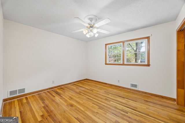 spare room with a textured ceiling, wood-type flooring, and ceiling fan