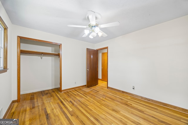 unfurnished bedroom with light hardwood / wood-style flooring, a closet, and ceiling fan