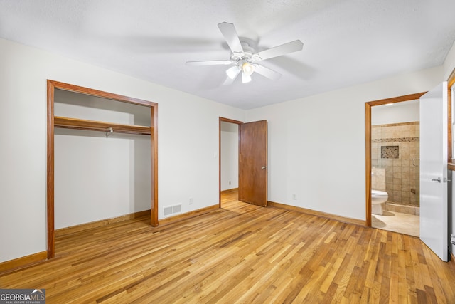 unfurnished bedroom with light hardwood / wood-style flooring, a closet, ensuite bathroom, and ceiling fan