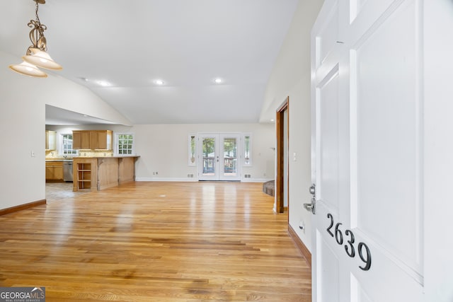 unfurnished living room with french doors, light hardwood / wood-style flooring, and vaulted ceiling