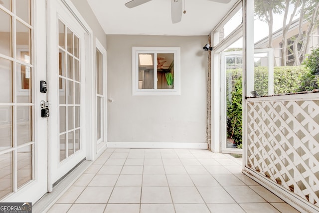 unfurnished sunroom with ceiling fan