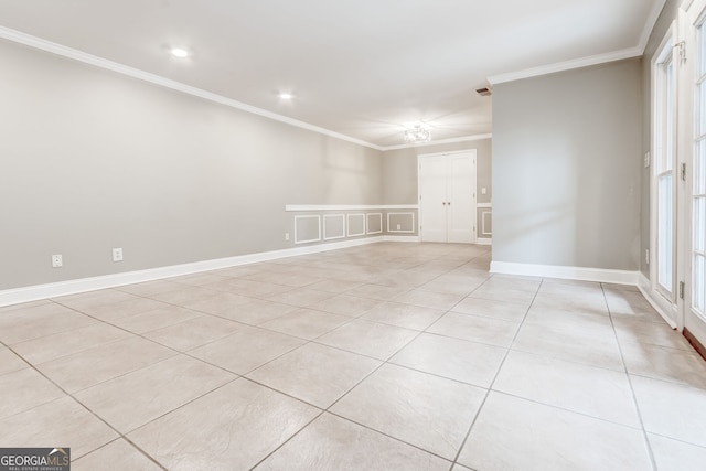 empty room featuring ornamental molding and light tile patterned flooring