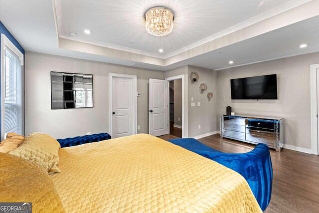 bedroom featuring an inviting chandelier, dark hardwood / wood-style floors, and a raised ceiling