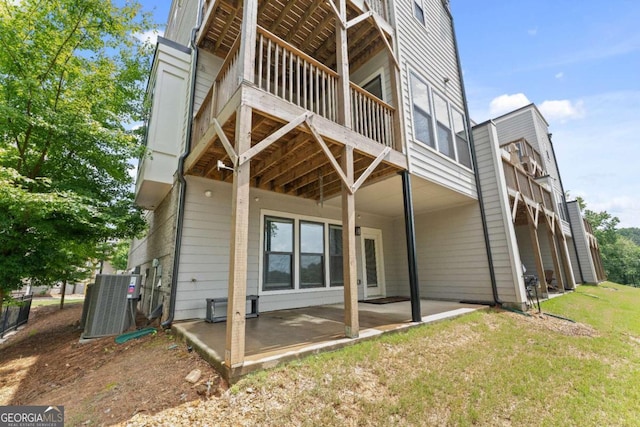 rear view of property featuring a patio area, a lawn, and central AC unit