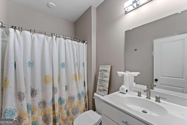 bathroom featuring vanity, toilet, and walk in shower