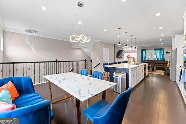 dining space featuring ornamental molding, sink, and dark hardwood / wood-style flooring