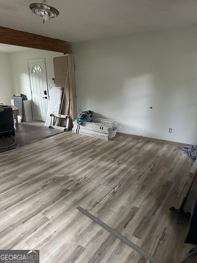 interior space with light hardwood / wood-style flooring and beam ceiling