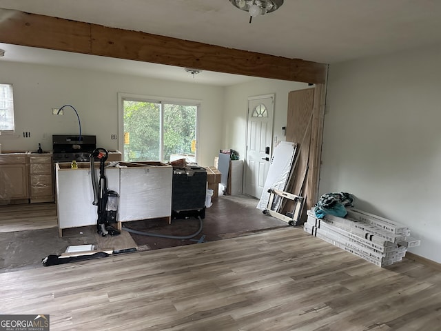 interior space featuring beamed ceiling and light hardwood / wood-style floors