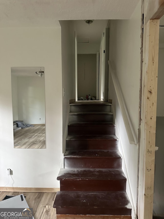 staircase with hardwood / wood-style flooring